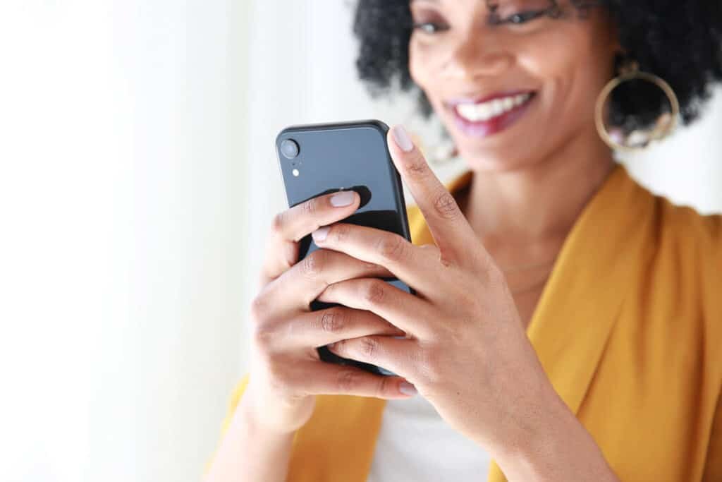 A woman checking her credit score with Borrowell on her phone